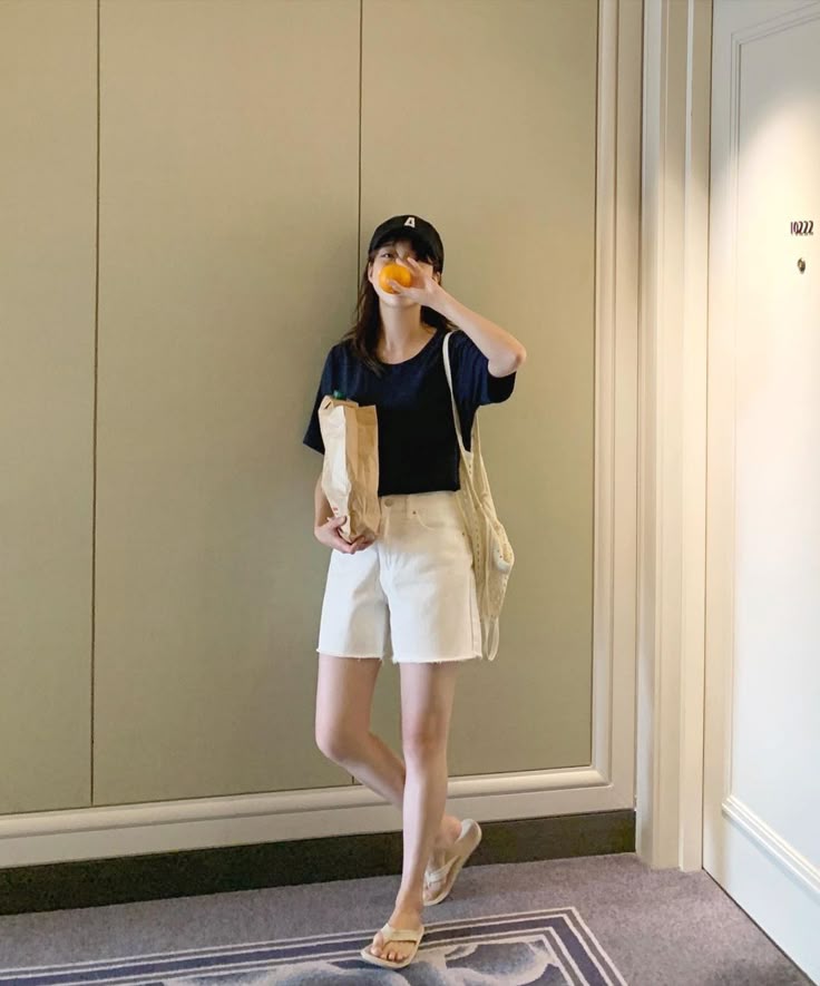 Kaos polos cerah dipadukan dengan celana pendek dan sandal