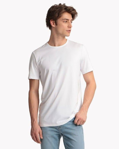 Kaos polos putih dengan jeans biru dan sneakers putih